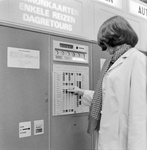 859257 Afbeelding van een vrouw bij een plaatskaartenautomaat van de N.S. te Utrecht C.S.